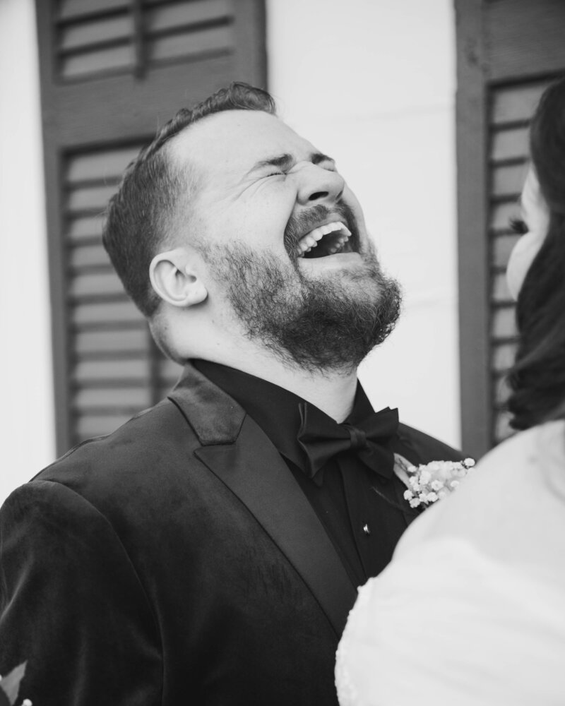 Groom seeing his bride and laughing with joy.