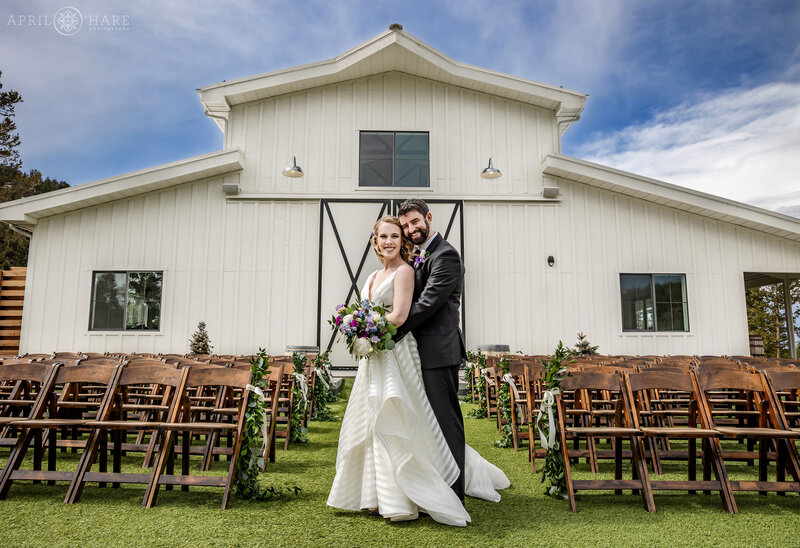 Pretty White Barn in the Backdrop for Wedding Portrait at The Woodlands in Colorado