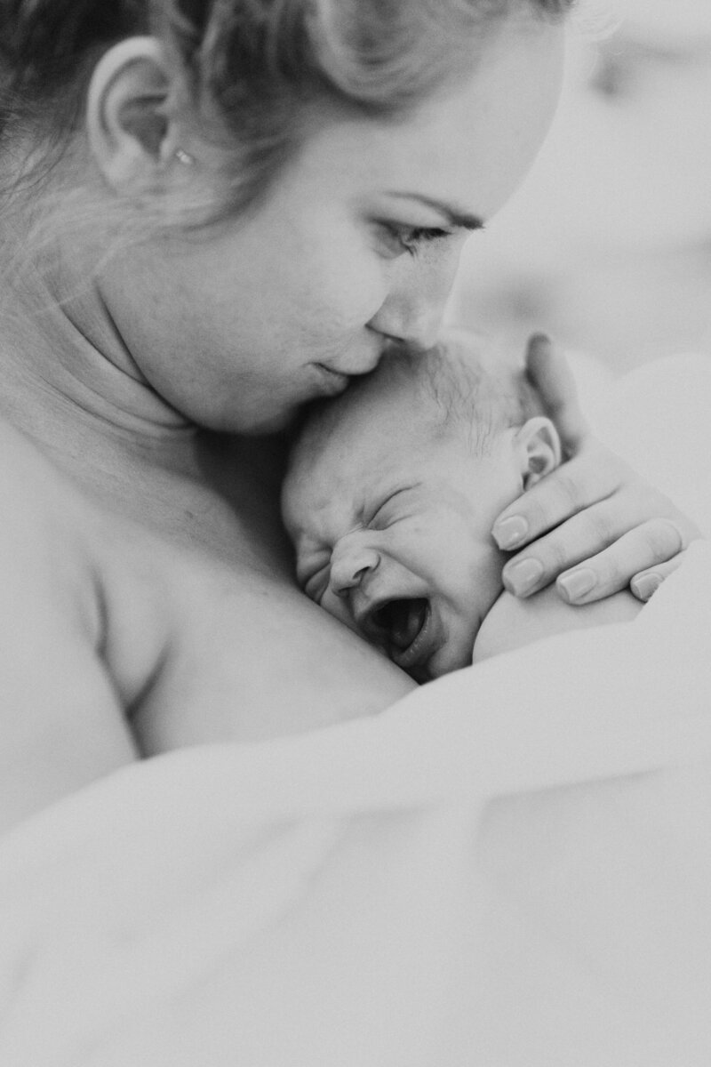 mother smelling newly born baby's head
