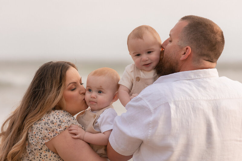 family photos with parents and two babies kisses on the Central Coast in Pismo Beach