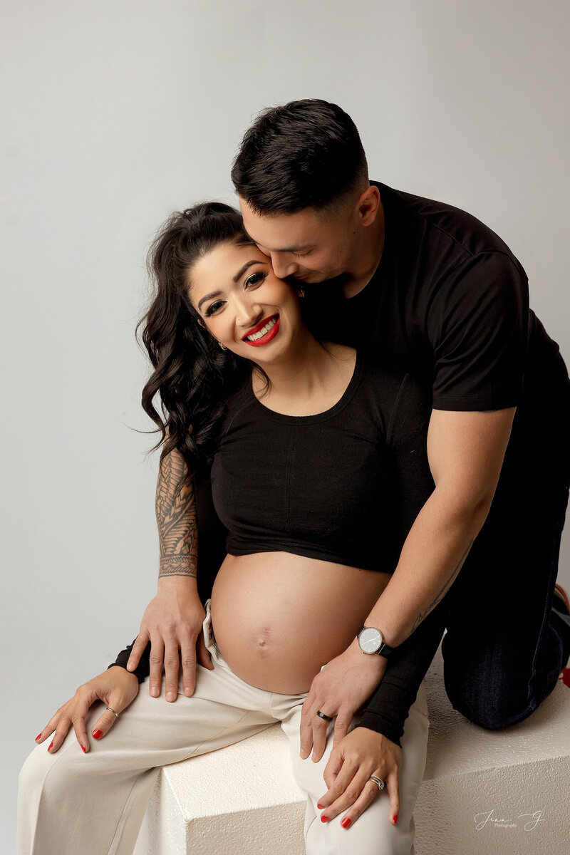 A man and women are posed happily for a Couples Maternity Photoshoot in Coquitlam