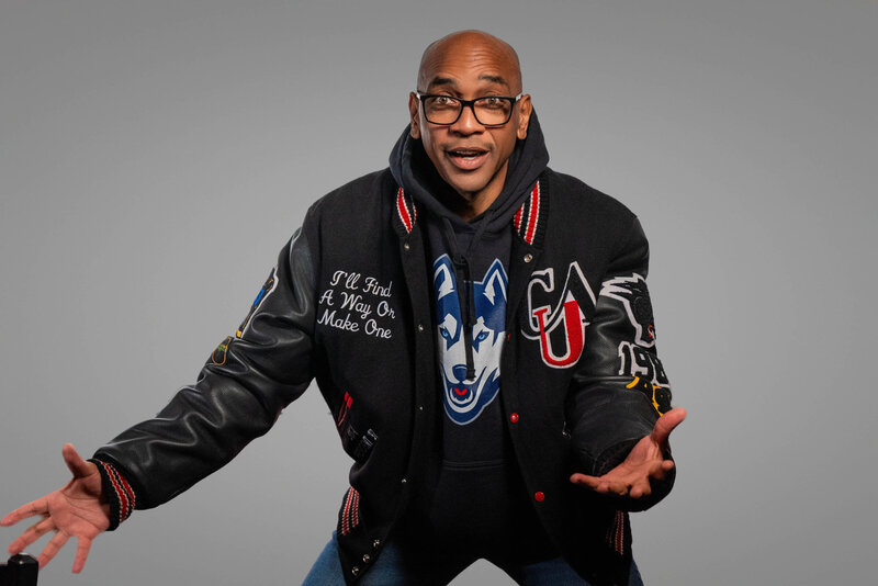 A person with glasses with their arms out 