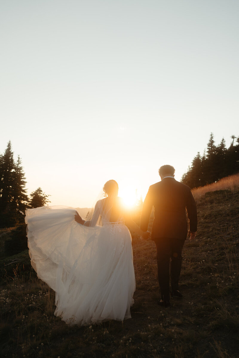 A couple walks towards the sunset after an Olympic National Park Wedding.