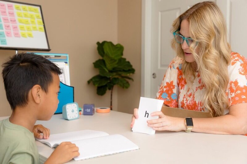 Reading specialist shows grapheme cards to 6 year old boy in a visual drill