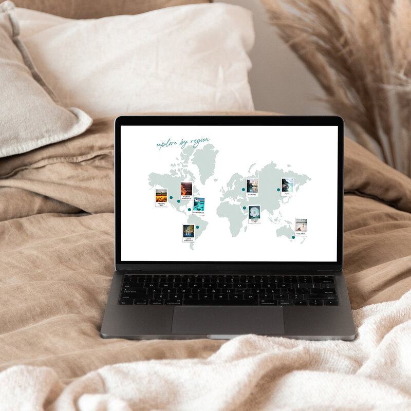 Laptop on bed open with world map on the screen