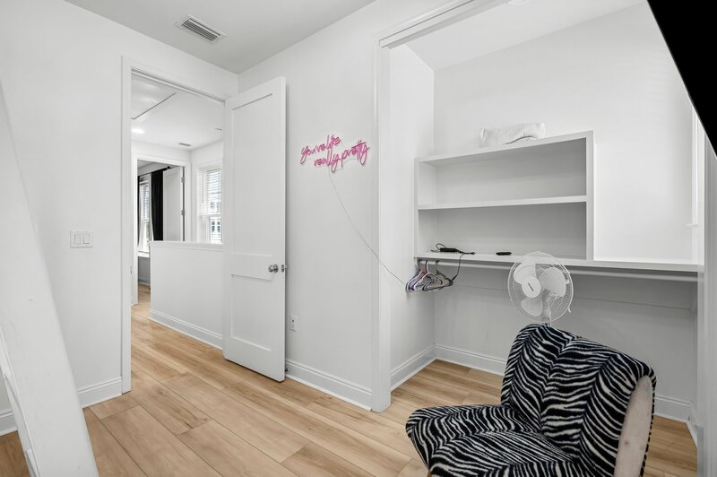 Zebra-print seating and pink neon 'you're like really pretty' sign inside closet nook—perfect for a selfie moment at this vibrant PCB rental.