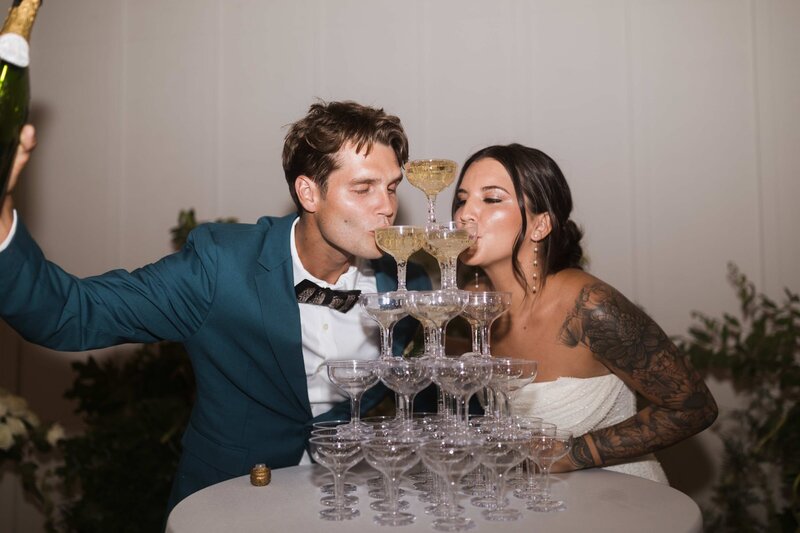 bride and groom drink from champagne tower at charlotte reception