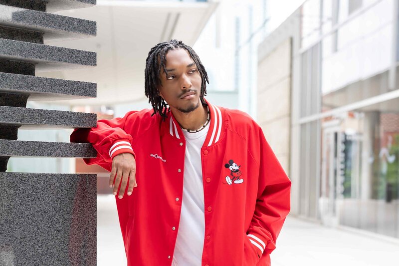 Professional senior pictures of a young man in a unique red jacket taken at his high school in Dallas, TX