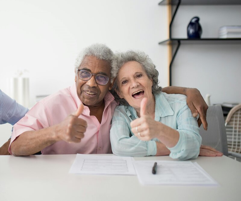 picture of a senior couple raising their thumbs