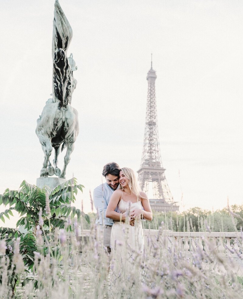 newly engaged couple laughing at the eiffel tower in paris