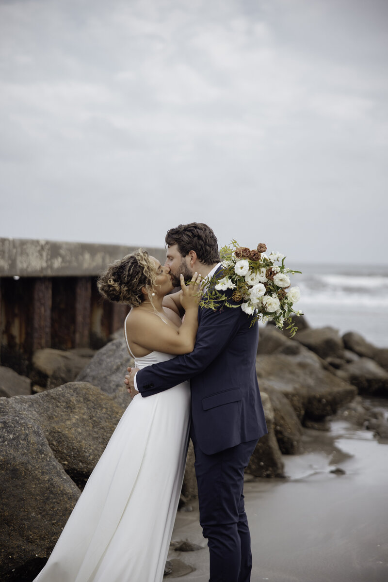 destination photographer captures couple kissing on the beach during their luxury wedding