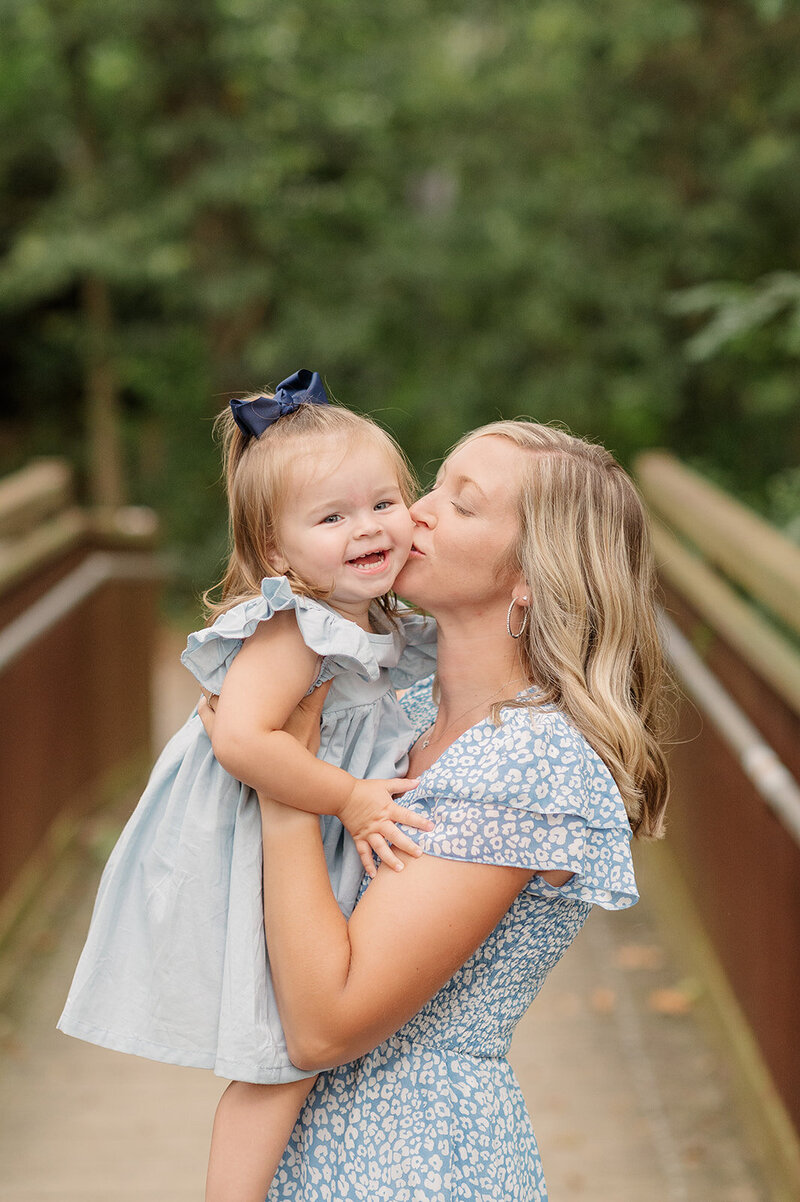 mother kissing daughter in a bridge in lancaster pa family session