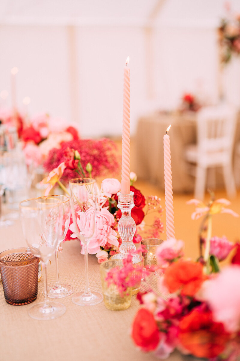 Pink, red, and gold wedding table setting inside Came House