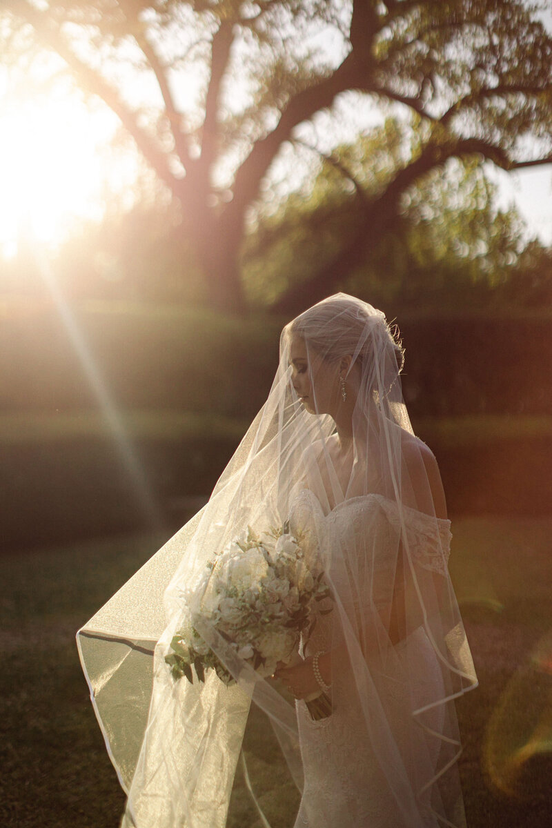Bride in white wedding dress walking in garden