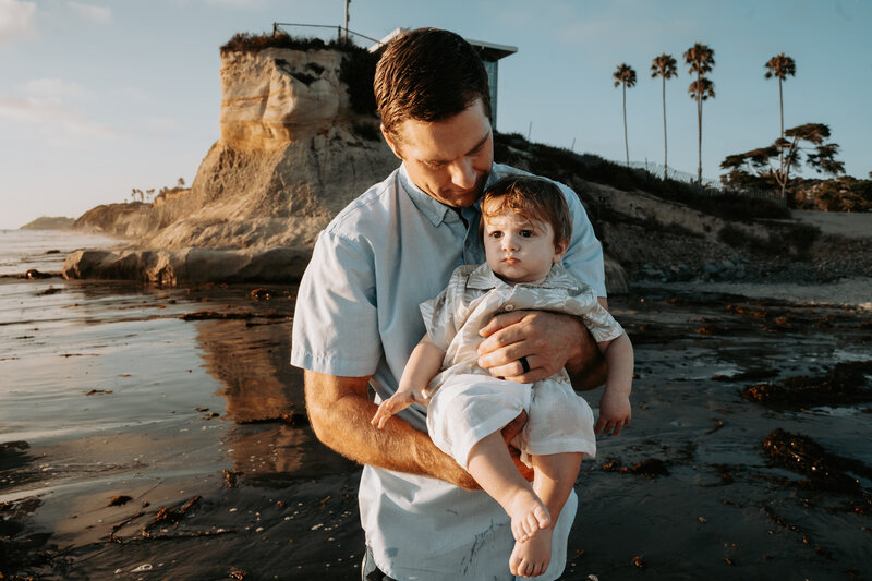 Image of father holding son at the beach.