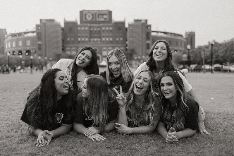 Senior girl friends laying on the grass and laughing