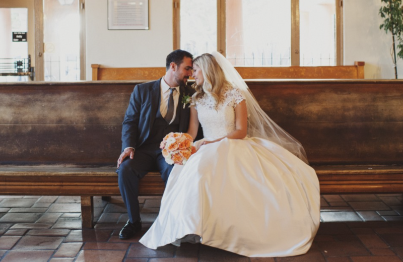 bride and groom sitting together on a church pew