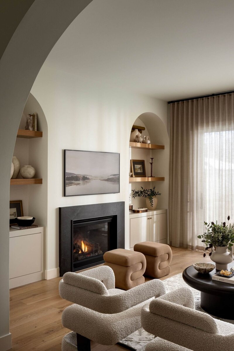 Arched Living Room with caramel and cream tones with cozy fireplace. 