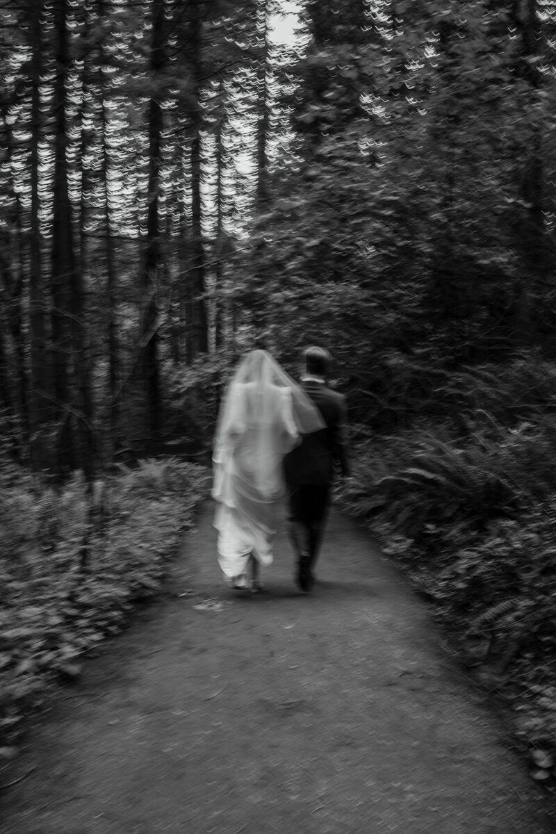 Bride and groom hiking through forest