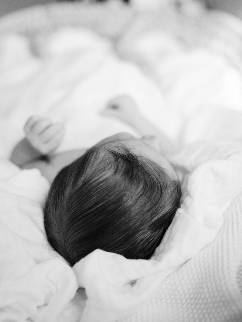 A close-up of a baby's head of hair while the baby is wrapped in a blanket during a Richmond newborn photography session by Katie Stansfield Photography.