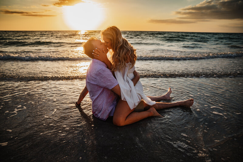 Shannon Lee, a Florida elopement photographer capturing a passionate kiss between a couple on the beach during sunset.