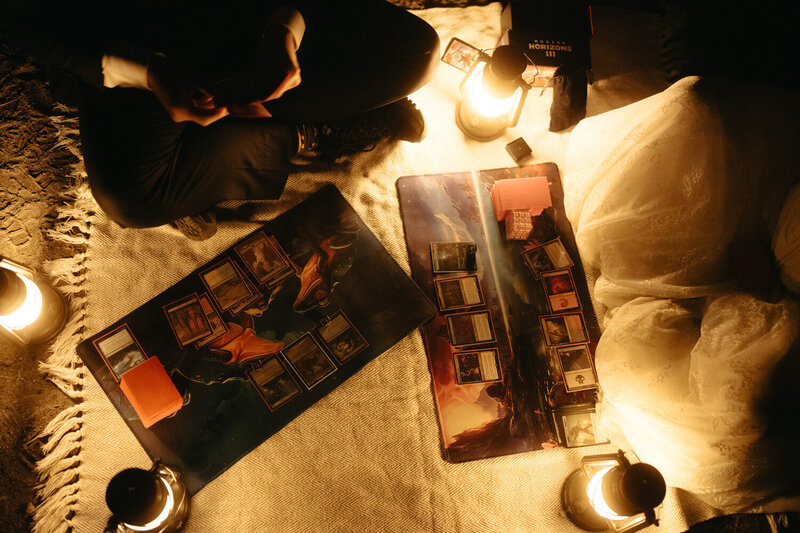 Unique Elopement Ideas | An eloping couple playing Magic the Gathering card game lit by fantasy-style lanterns