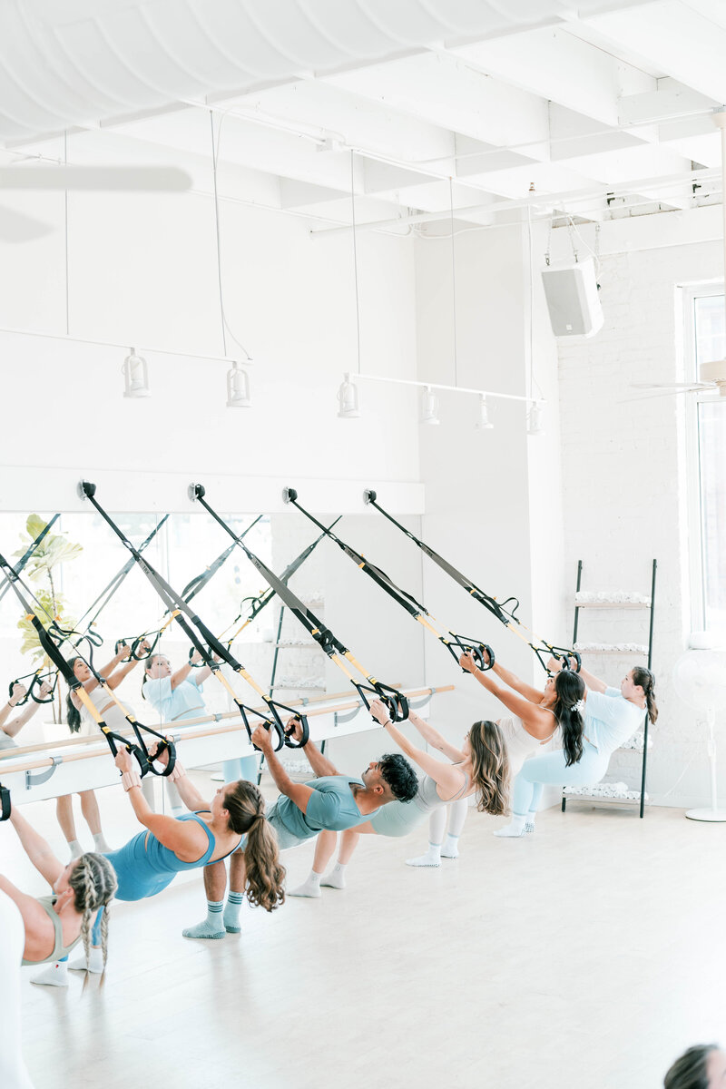 people in class doing a trx inveerted row