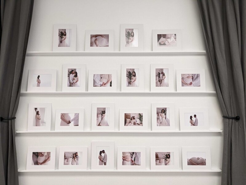 Images framed in white mats displayed on multiple shelves