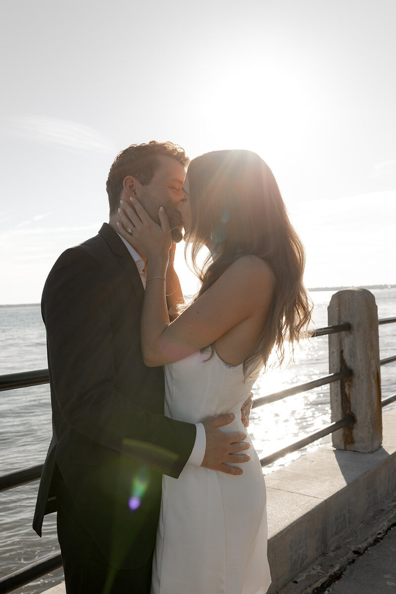 Charleston Engagement photo taken at the battery . Couple kissing with sun in background