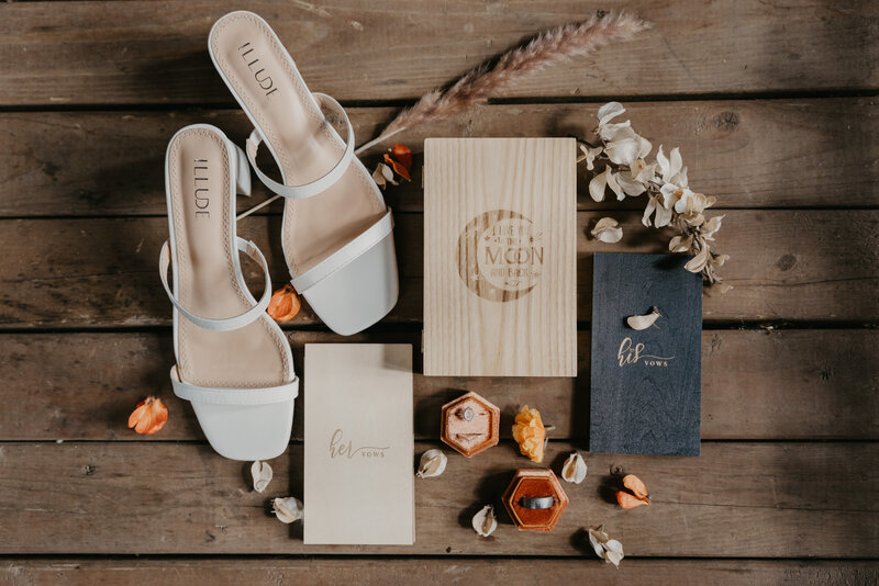Intimate elopement getting ready details including bridal shoes, vow books, rings during getting ready portraits.