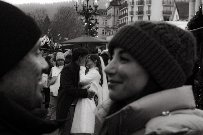 Hochzeitspaar in der Menge des Weihnachtsmarktes zwischen Menschen fotografiert