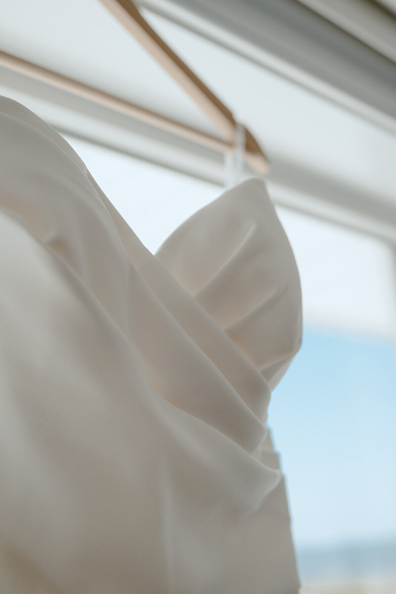 Wedding dress hanging in the window 