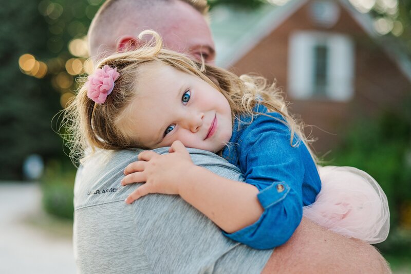 little girl with dad and pregnant mom holding belly