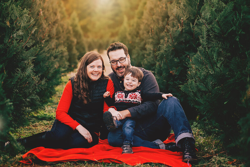 christmas tree farm family holiday photos mom dad baby sitting on red blanket lake wylie
