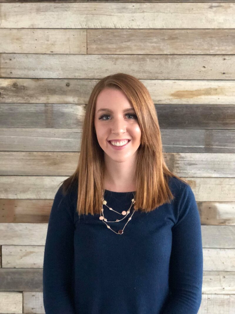 Zoe Schroeder, registered dietitian and fitness coach, smiling in workout gear, ready to guide clients through personalized fitness and nutrition programs.