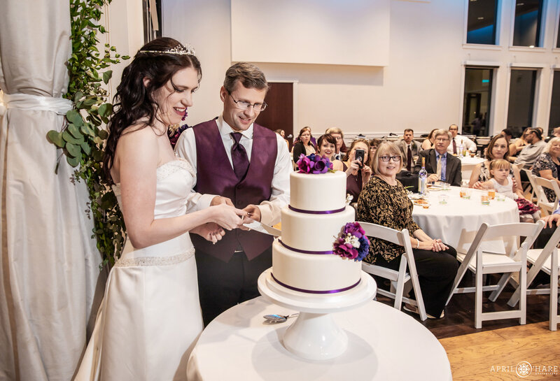 Bride and groom cut their wedding cake at Ashley Ridge Wedding Reception in Colorado