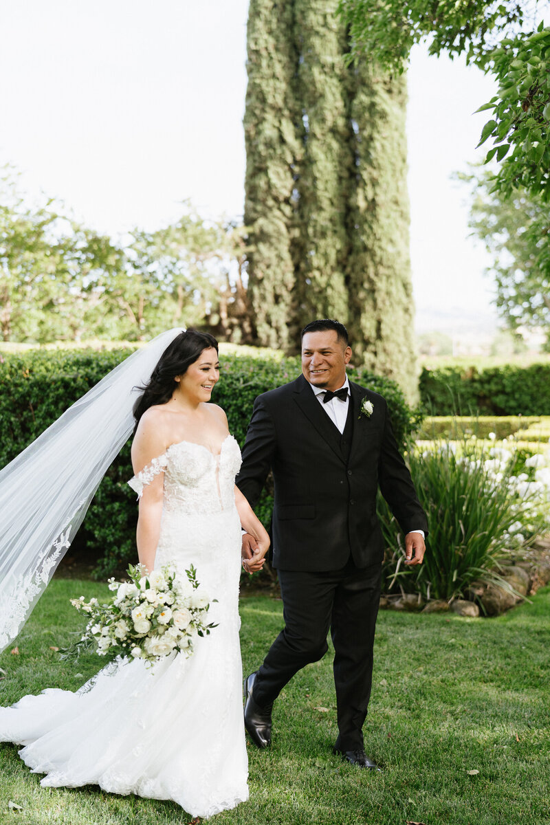 Bride and groom walking holding hand. Black tie wedding at Garre Vineyard in Livermore