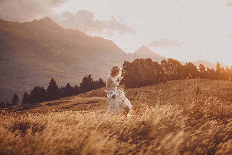 A women photographed walking through a field in a 3N7LOVE couture dress.
