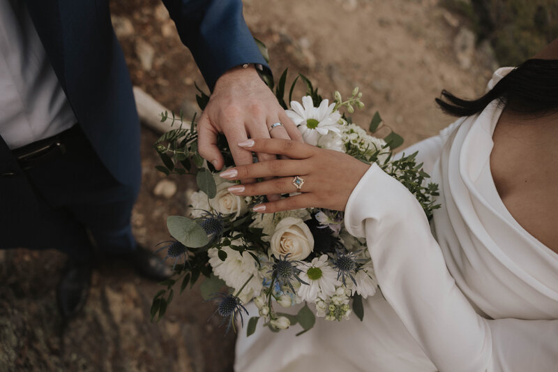bride and groom ring photo with their wedding flower bouquet