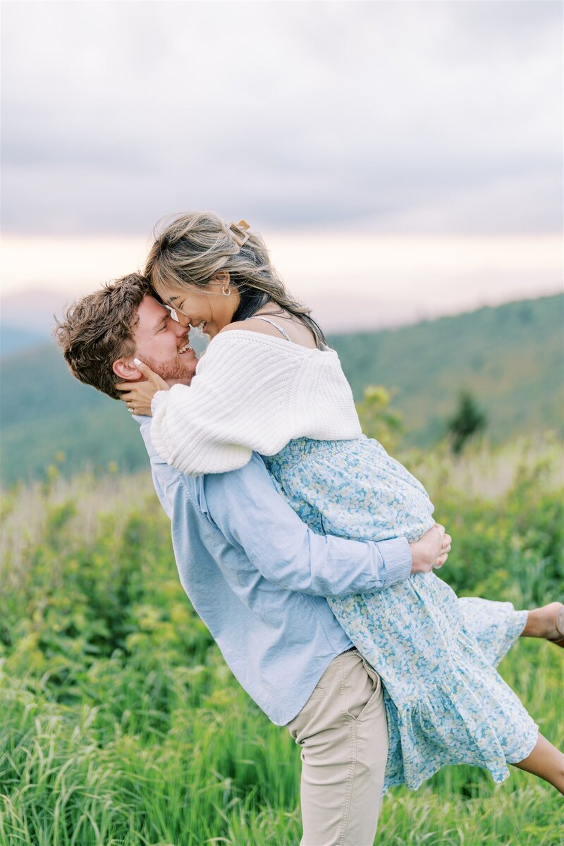 A documentary-style fine art engagement photo of a couple embracing on the scenic trails of Black Balsam Knob, captured by Jessica Leigh Photography.