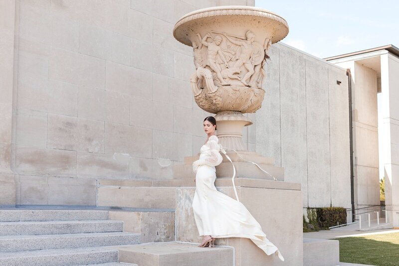 editorial bridal portait of her by the NOLA greek vase as her dress flows 