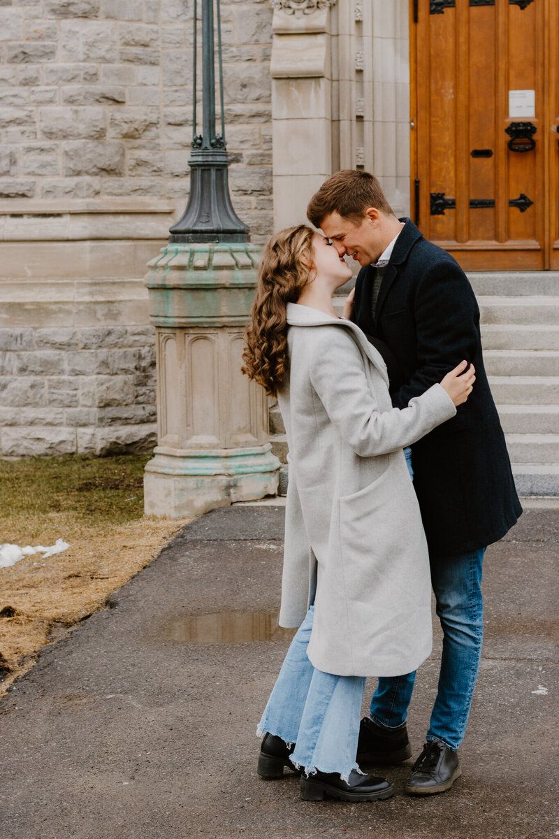 A candid, sunlit moment of a couple holding hands and laughing during a golden hour session in Montreal.