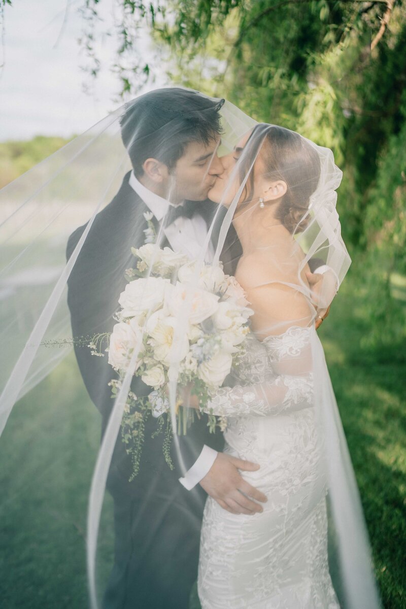 couple in front of a pavilion  by the water at their brookside gardens wedding