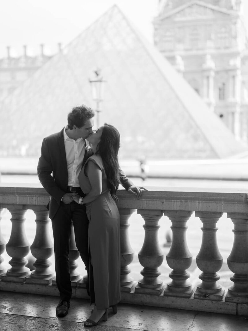 a couple kissing in front of the louvres