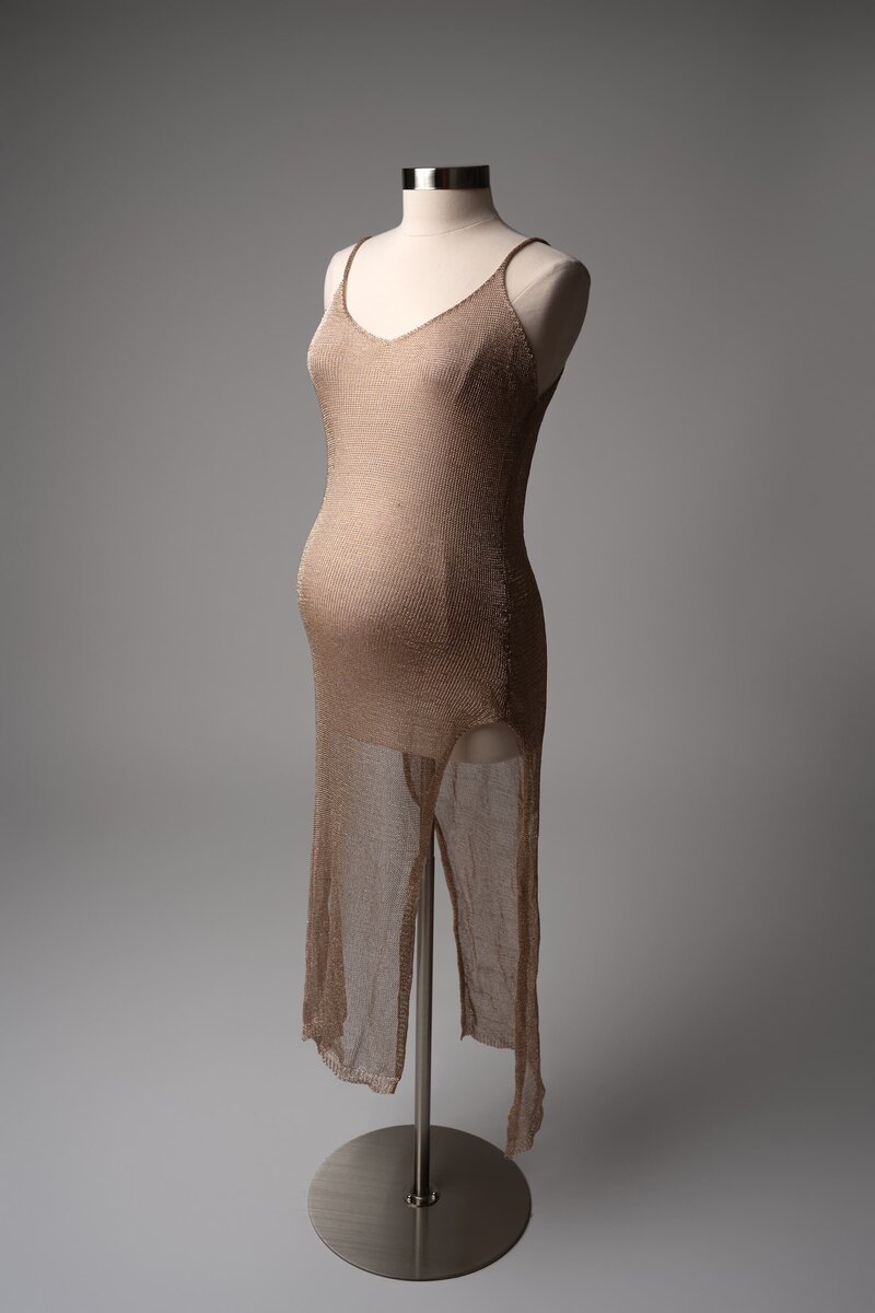 Rose gold slip dress with open sides, displayed on mannequin for studio sessions