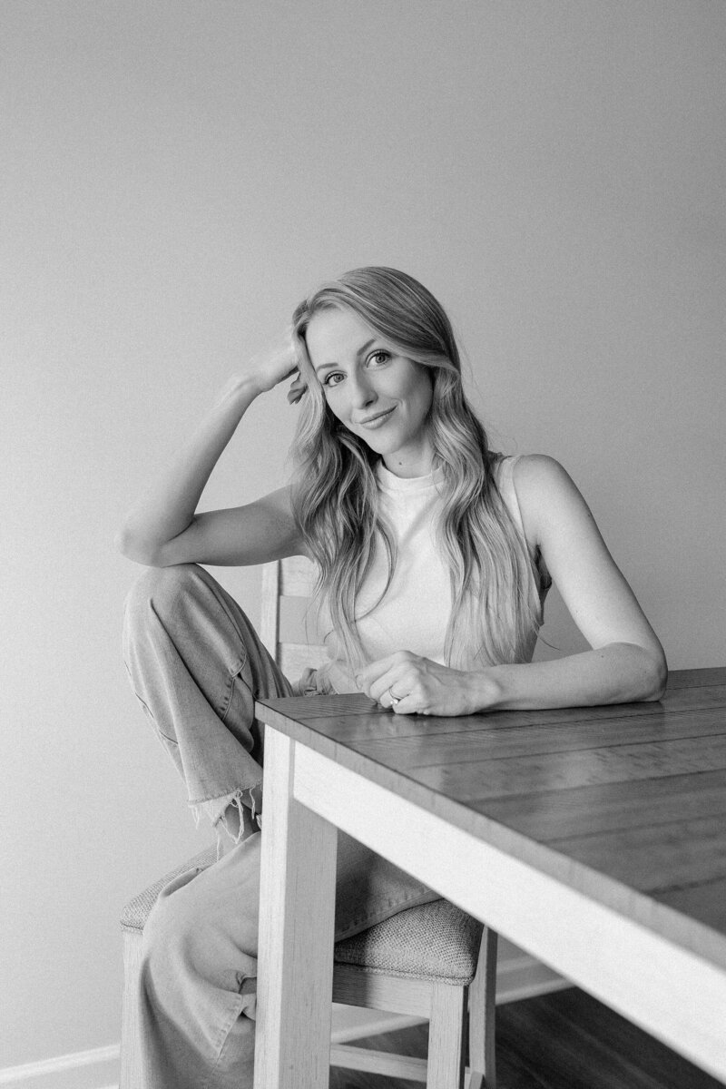 black and white image of woman sitting at a table