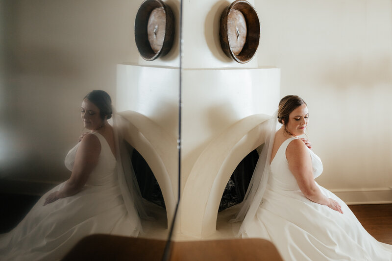 Arizona wedding photographer captures the bride and the reflection of her looking over her shoulder while seated