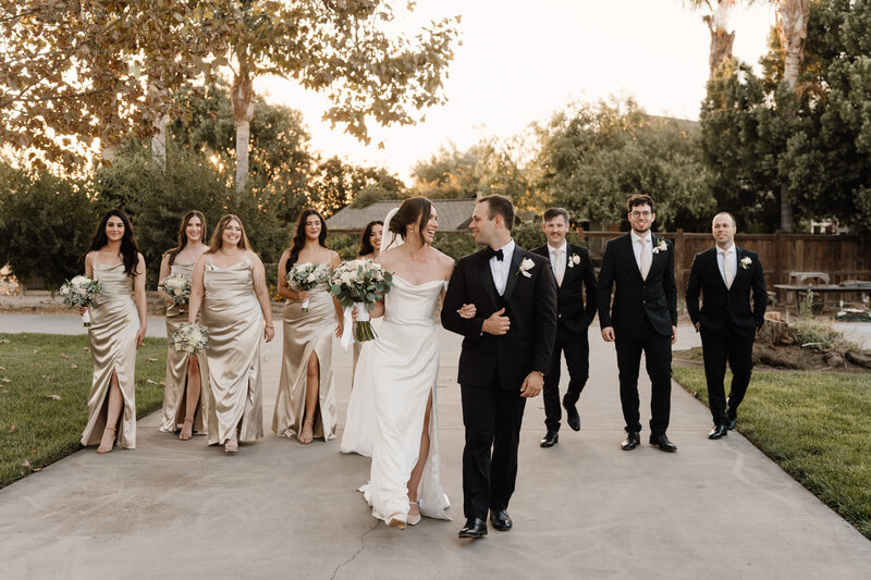 bride and groom holding hands on carmel coastline