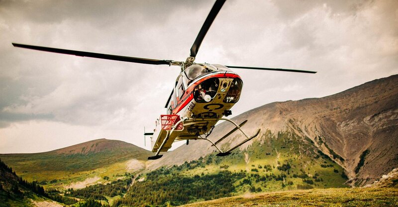 This dramatic photograph captures the belly of a helicopter as it lands in Banff National Park, carrying the bride for her helicopter wedding. The powerful and striking image, combined with the stunning landscape, creates a breathtaking and unforgettable moment.