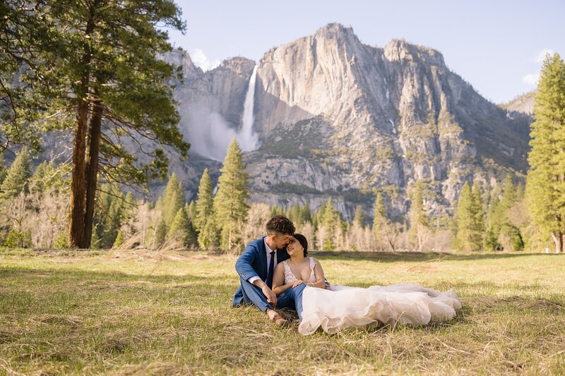 Bride and Groom sit in front of Yosemite Falls during their spring Yosemite adventure elopement.